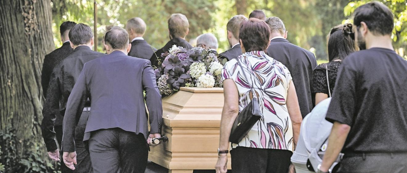 Sargträger und Trauernde auf dem Weg zum Grab.