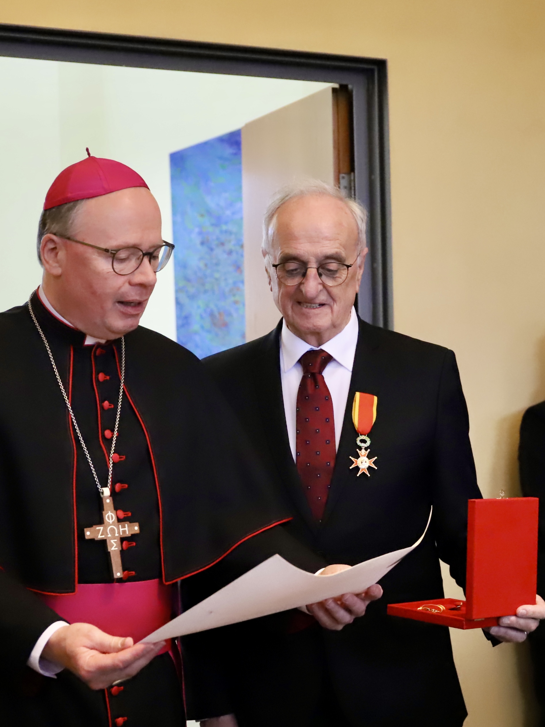 Bischof Ackermann und Manfred Boßmann betrachten die Urkunde.