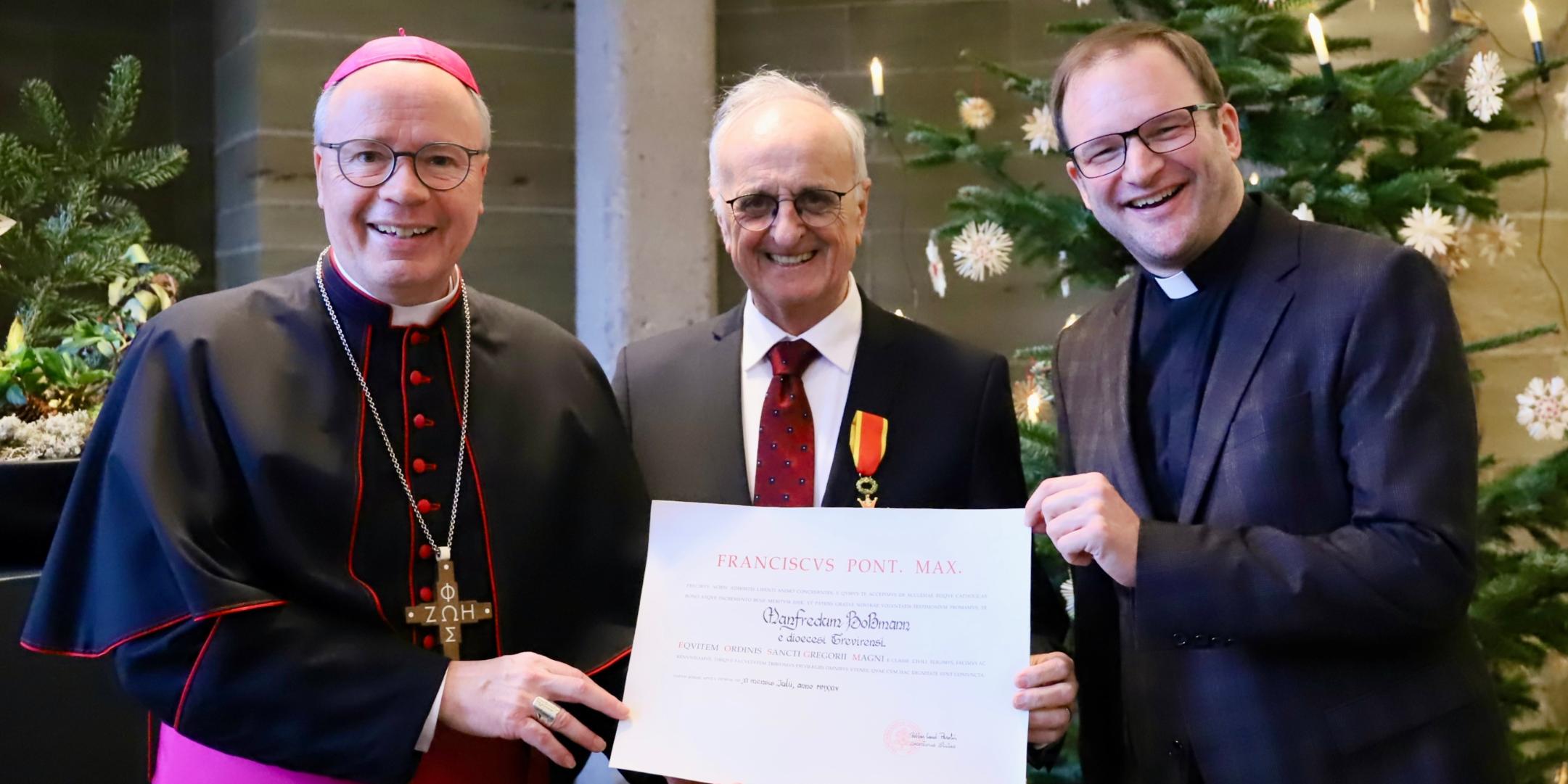 Gregoriusordensträger Manfred Boßmann (Mitte) mit Bischof Ackermann (li.) und Dekan Frank Kleinjohann