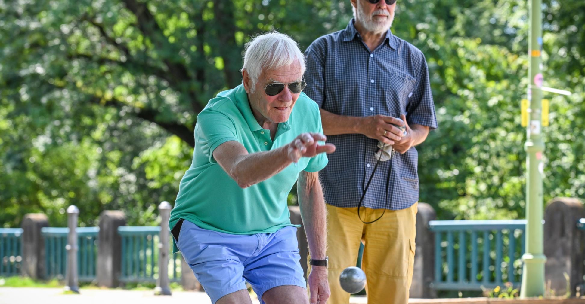 Zwei Männer spielen Boule.