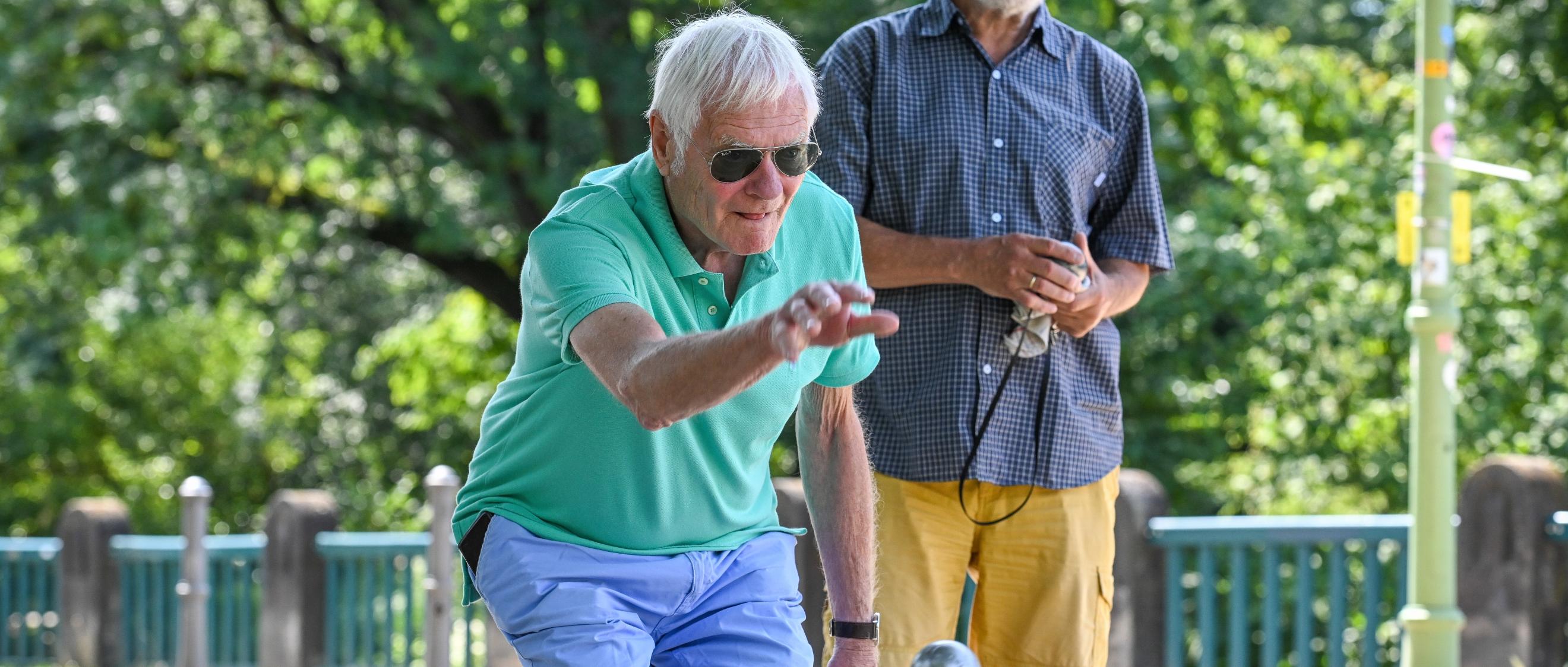 Zwei Männer spielen Boule.