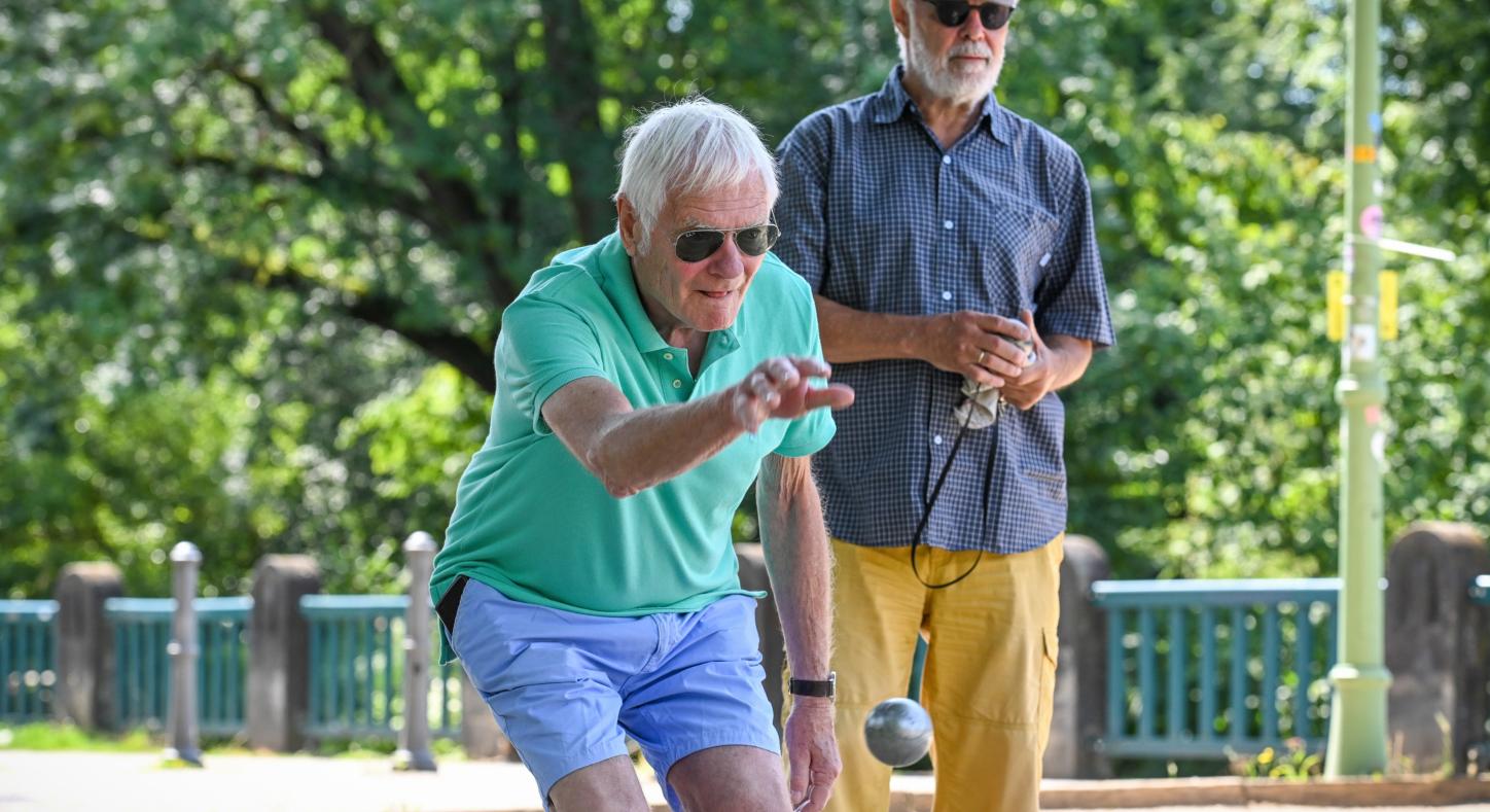 Zwei Männer spielen Boule.