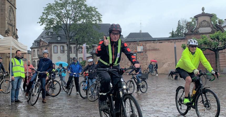 Viele Radfahrer, die im Regen ihre Runden um den Trierer Dom drehen.