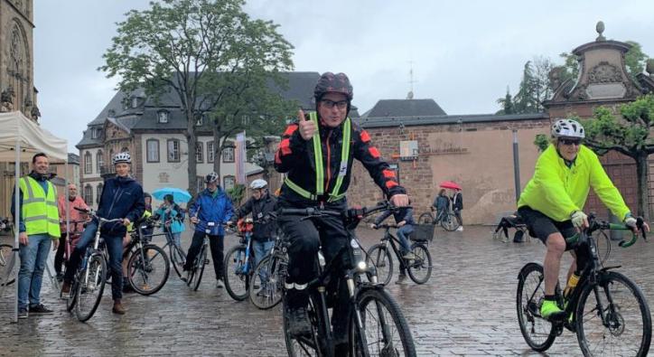 Viele Radfahrer, die im Regen ihre Runden um den Trierer Dom drehen.