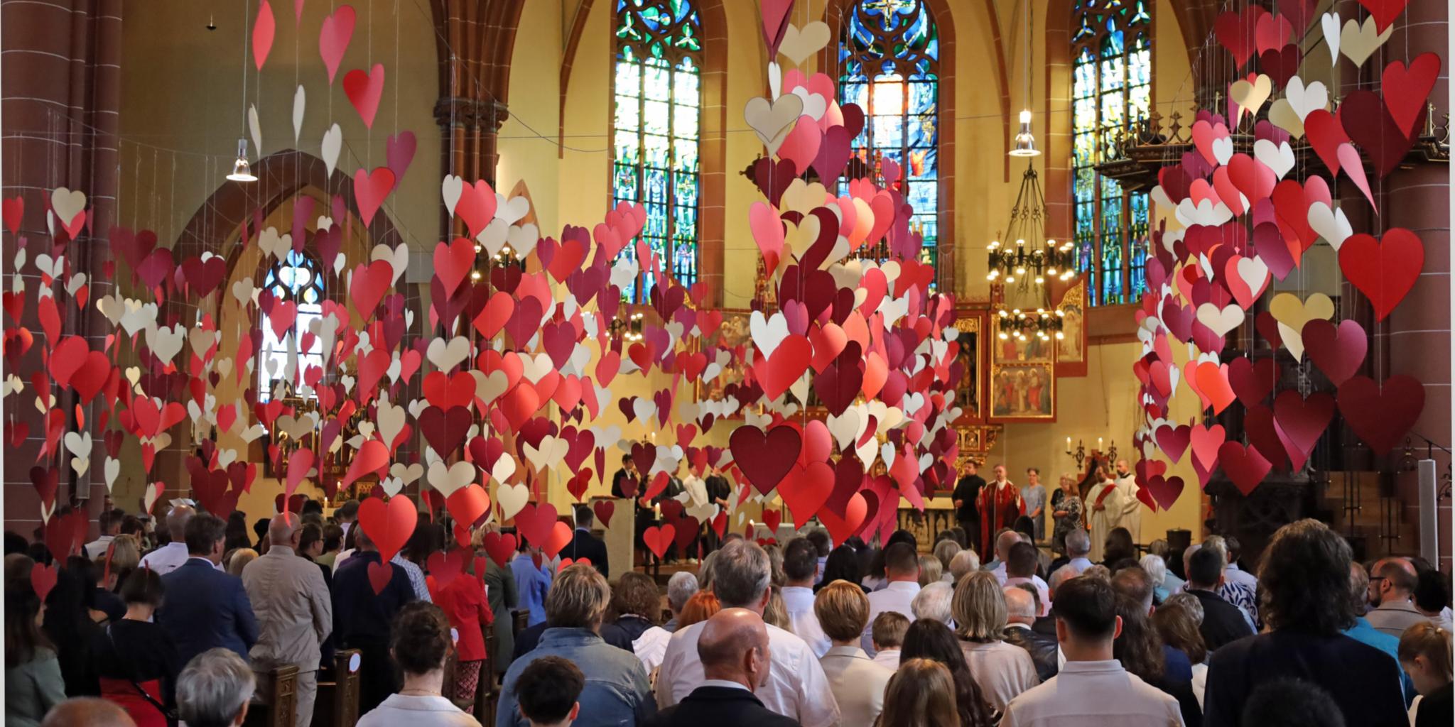 Von der Decke der Heilig-Kreuz-Kirche in Bad Kreuznach hängen hunderte rote Herzen.