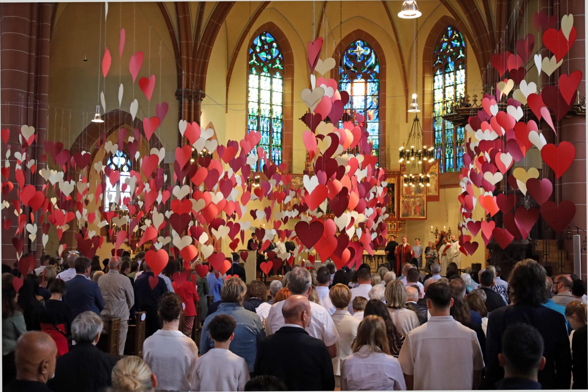 Von der Decke der Heilig-Kreuz-Kirche in Bad Kreuznach hängen hunderte rote Herzen.