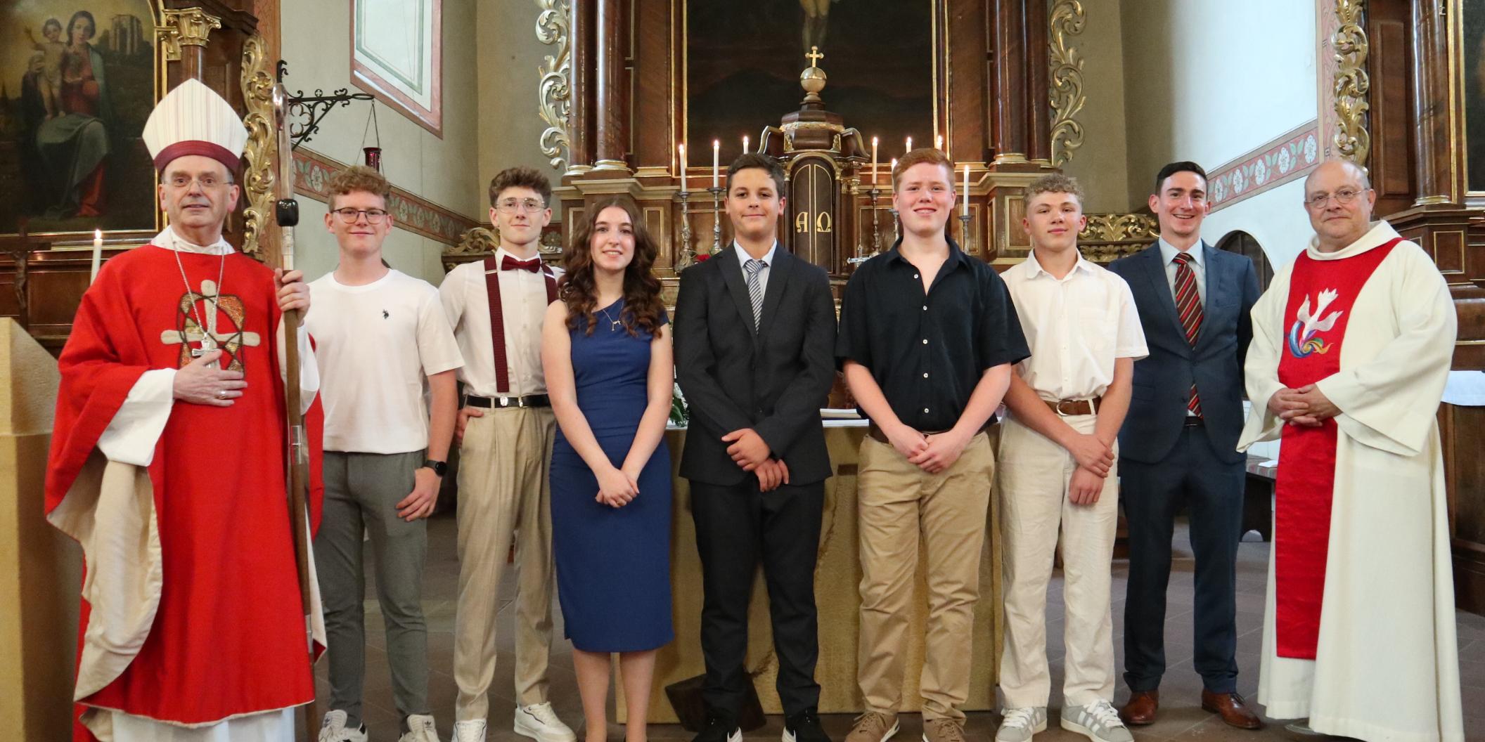 Weihbischof Robert Brahm (links), Pfarrer Michael Knipp (rechts) und Pastoralreferent Tobias Petry (Zweiter v. rechts) gratulieren den jungen Menschen in der Kirche St. Nikolaus in Bacharach zu ihrer Firmung.