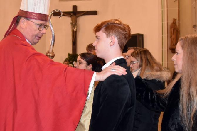 Bischof Ackermann legt einem Jugendlichen die Hand auf