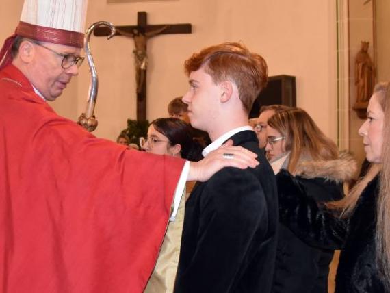 Bischof Ackermann legt einem Jugendlichen die Hand auf