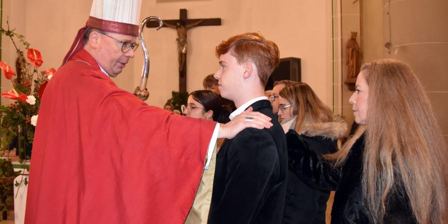 Symbolfoto einer Firmung aus 2024 Bischof Ackermann legt einem Jugendlichen die Hand auf