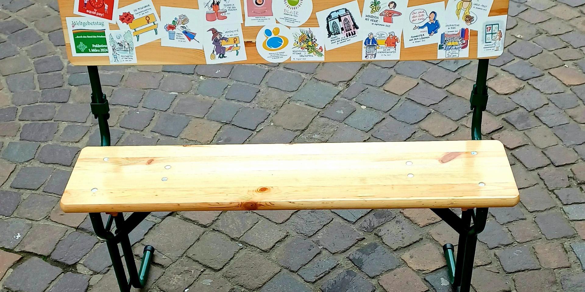 Eine Sitzbank, die mit Aufklebern beklebt ist.