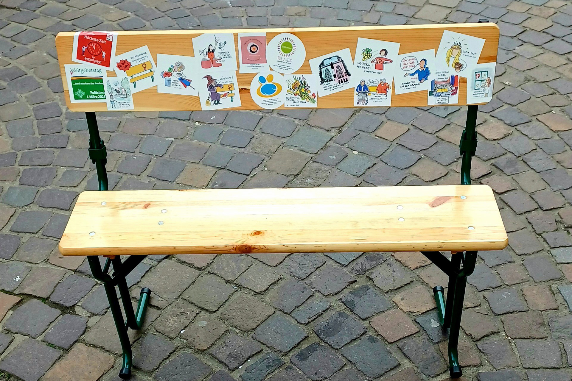 Eine Sitzbank, die mit Aufklebern beklebt ist.