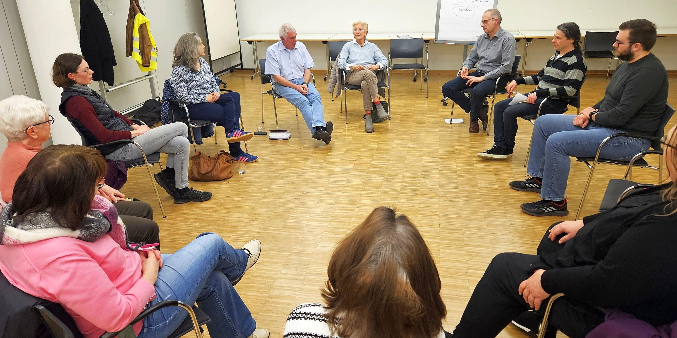 Menschen sitzen im Kreis und unterhalten sich