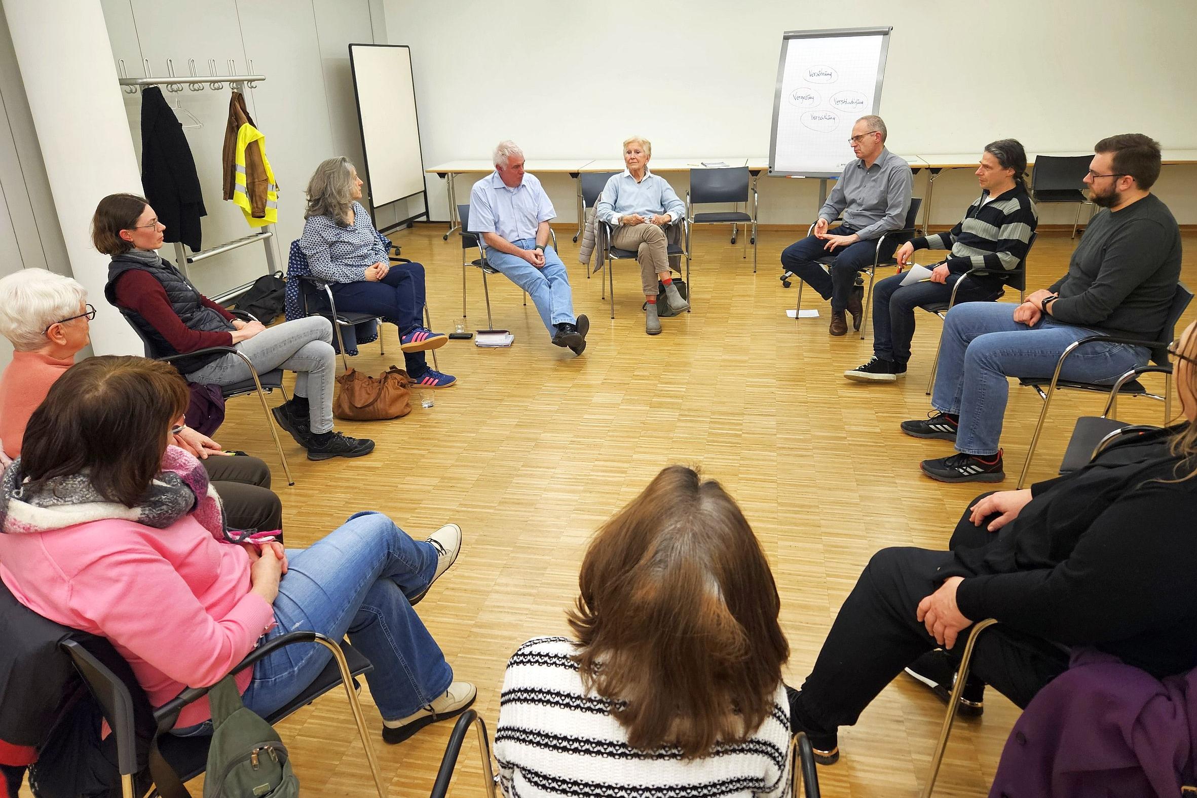 Menschen sitzen im Kreis und unterhalten sich