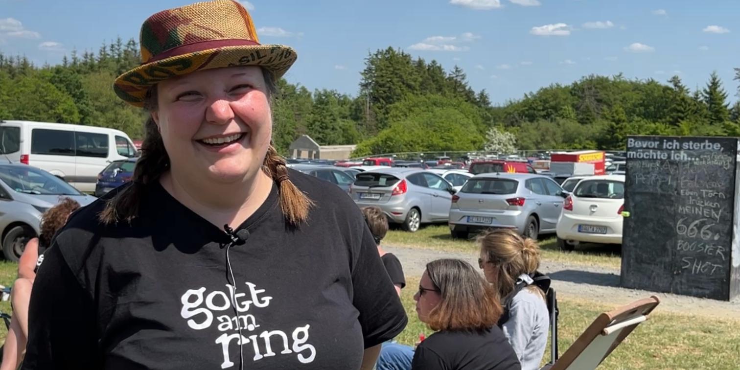 Eine Frau mit Hut und TShirt mit der Aufschrift 'Gott am Ring'