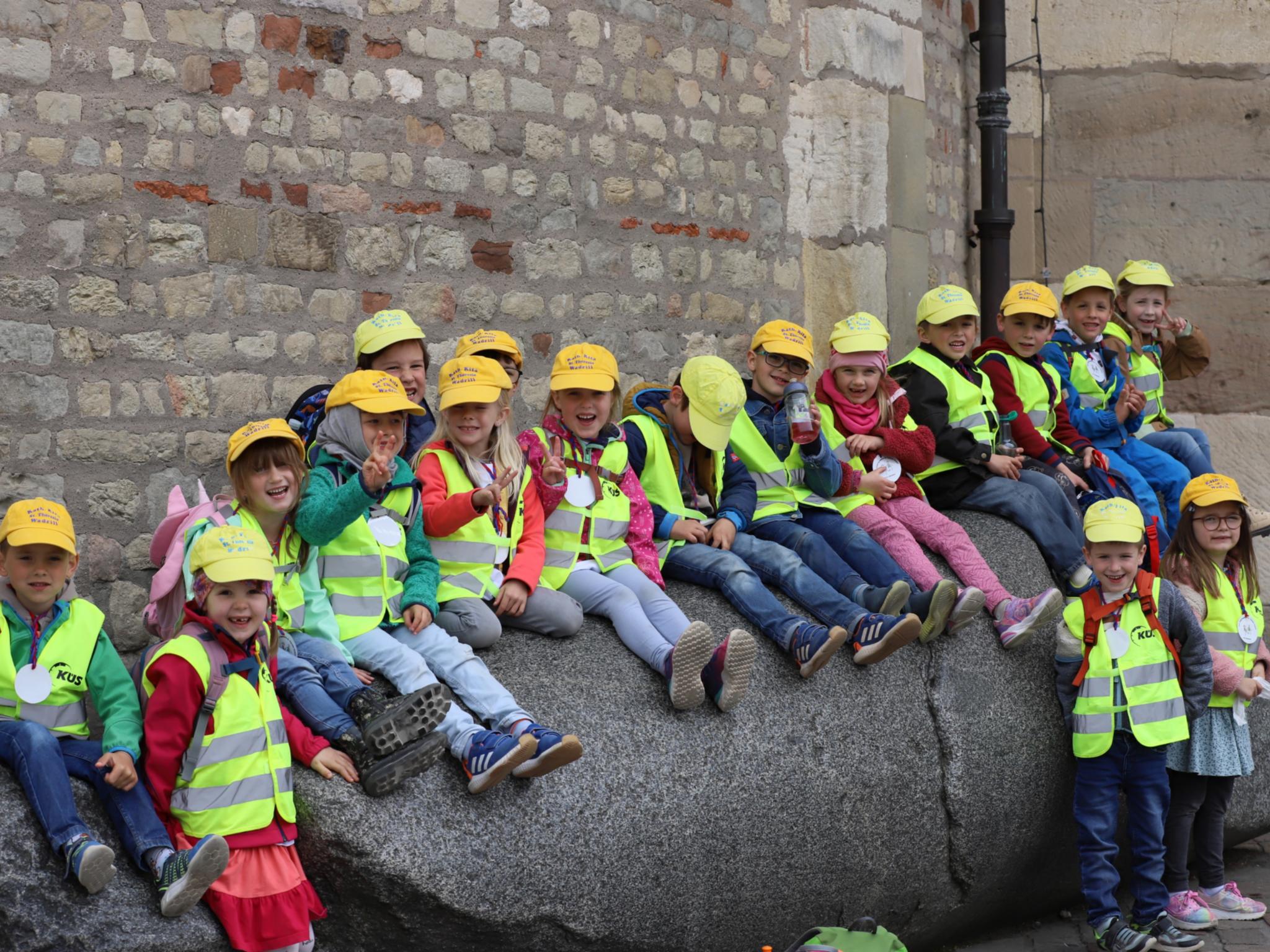 Kinder der Kita St. Theresia in Wadrill sitzen auf dem Domstein