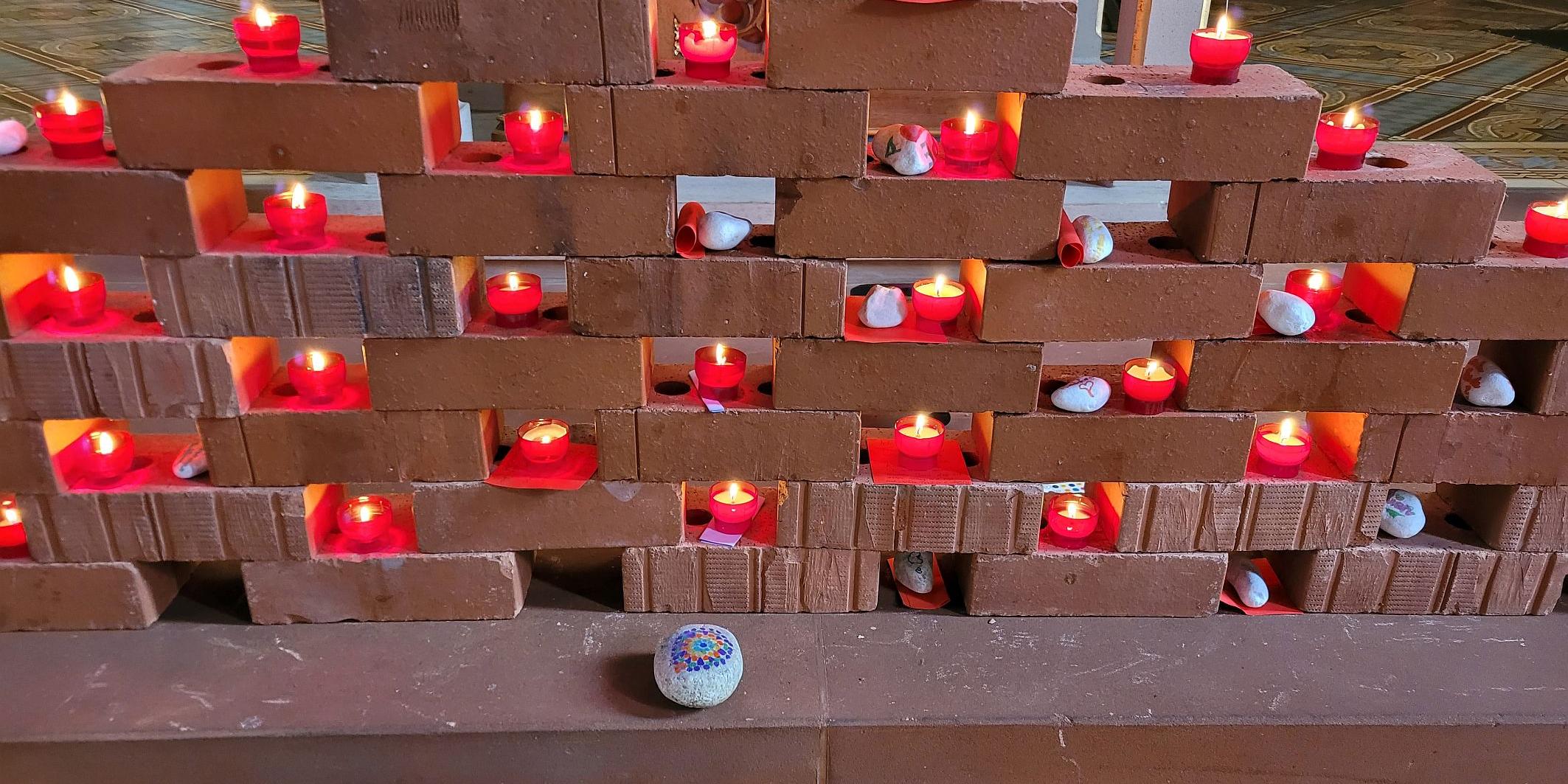 Die „Klagemauer“ aus Ziegelsteinen mit Kerzen und Zetteln.