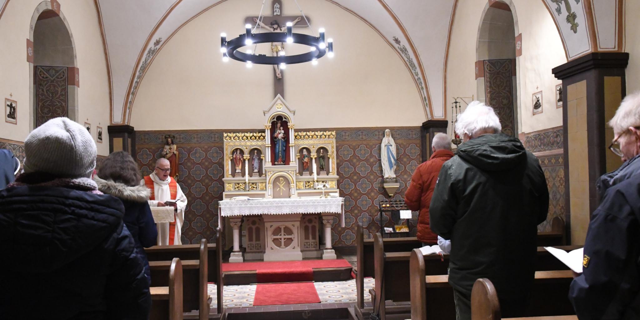 Auch im Winter gerne Gottesdienst feiern: Die Heizung unter anderem in den Lampen der Kapelle in Bitburg-Stahl wärmt bei ungemütlichen Außentemperaturen die Gemeinde auf.