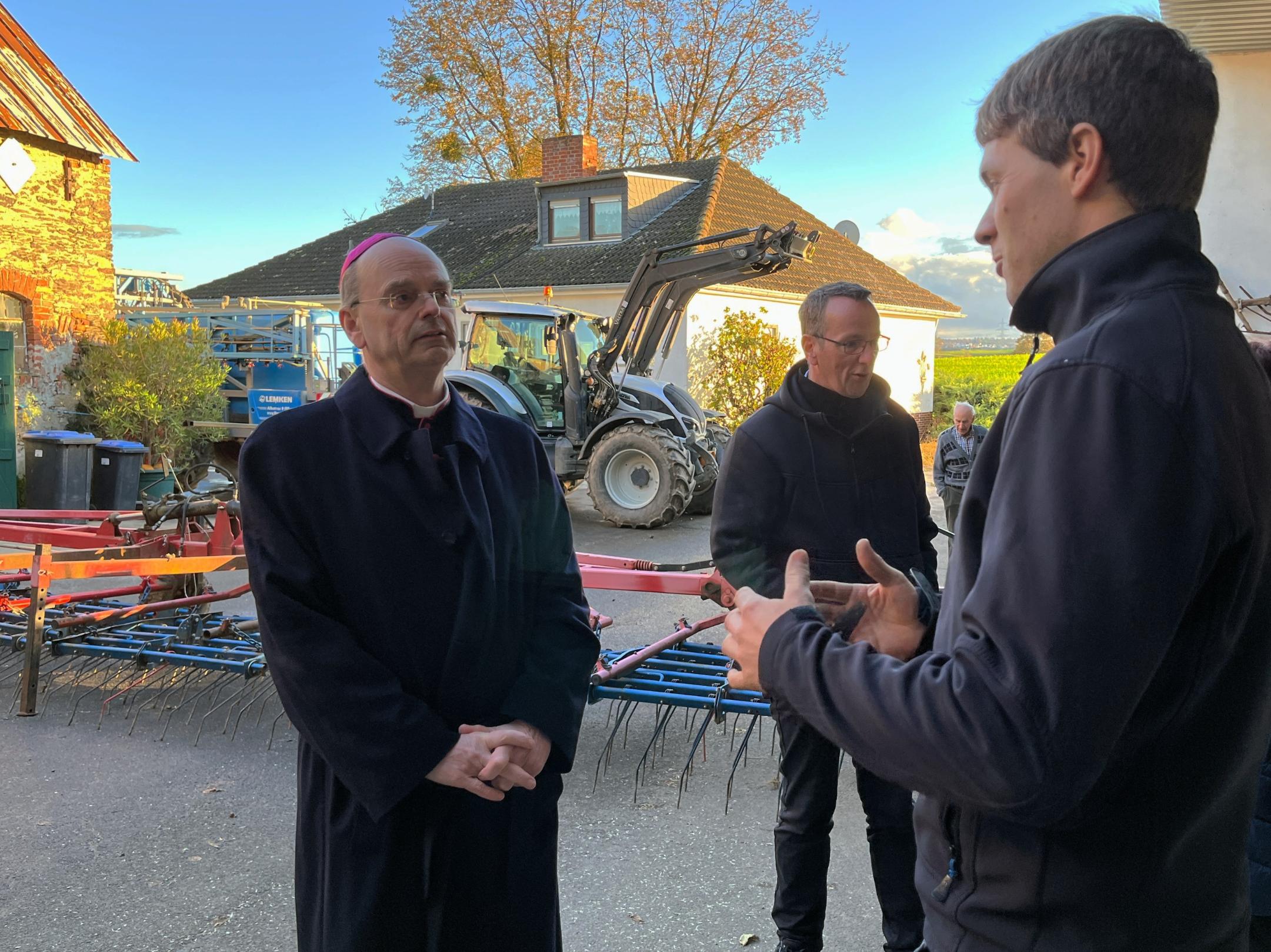 Stefan Gilles berichtet dem Weihbischof von den vielfältigen Herausforderungen für landwirtschaftliche Betriebe.