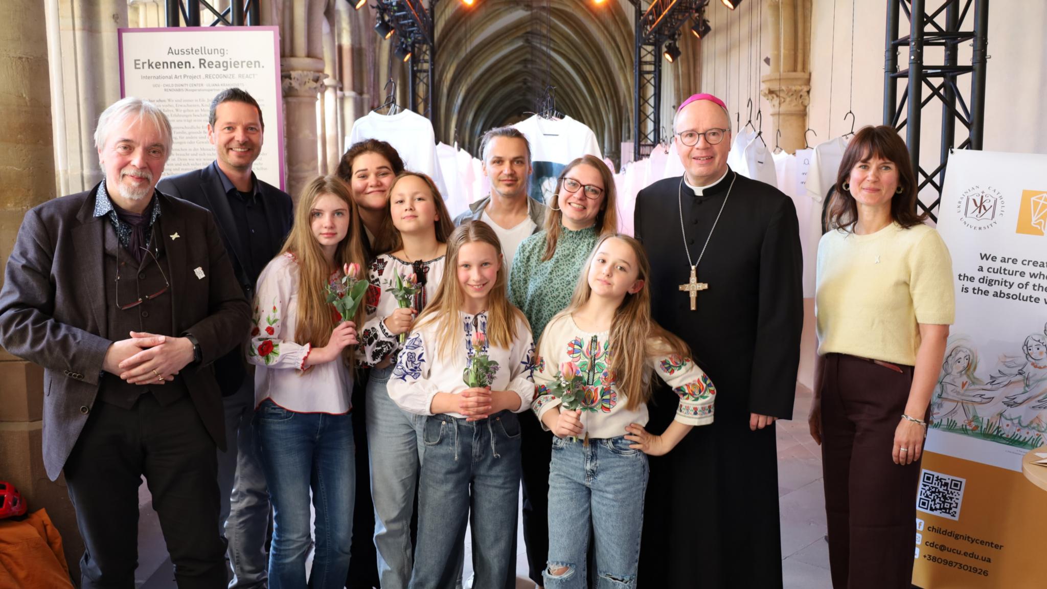 Gruppenfoto: Dr. Andreas Zimmer, Dr. Thorsten Hoffmann, Khrystyna Shabat, Tomek Welke, Ivanka Rudakevych, Bischof Dr. Stephan Ackermann und Sarah Schmitz (vlnr.) zusammen mit Kindern des Kinderchor „Bravo“ der Deutsch-Ukrainischen Gesellschaft Trier.