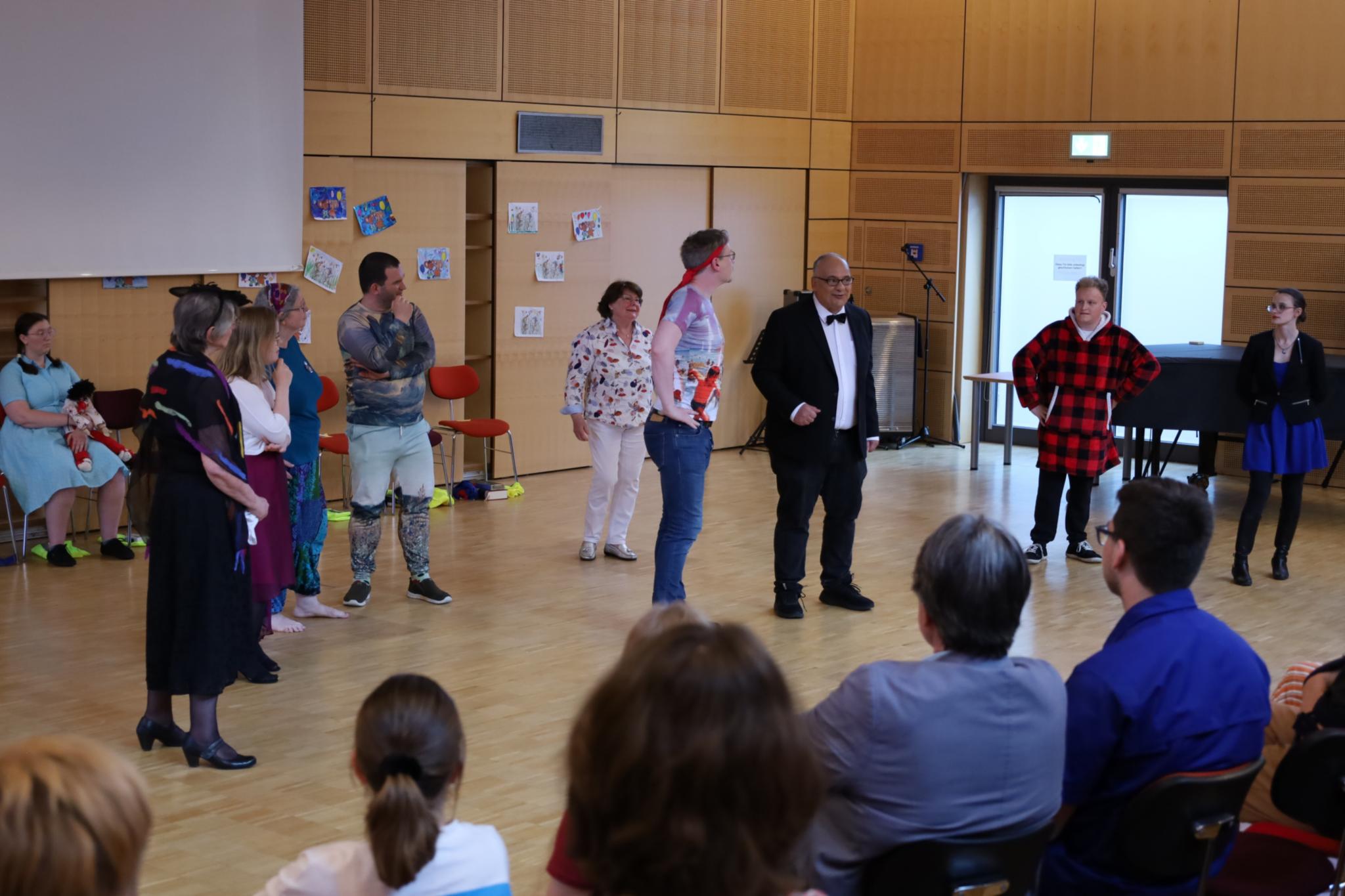 Eine Gruppe von verkleideten Erwachsenen führ ein Theaterstück auf