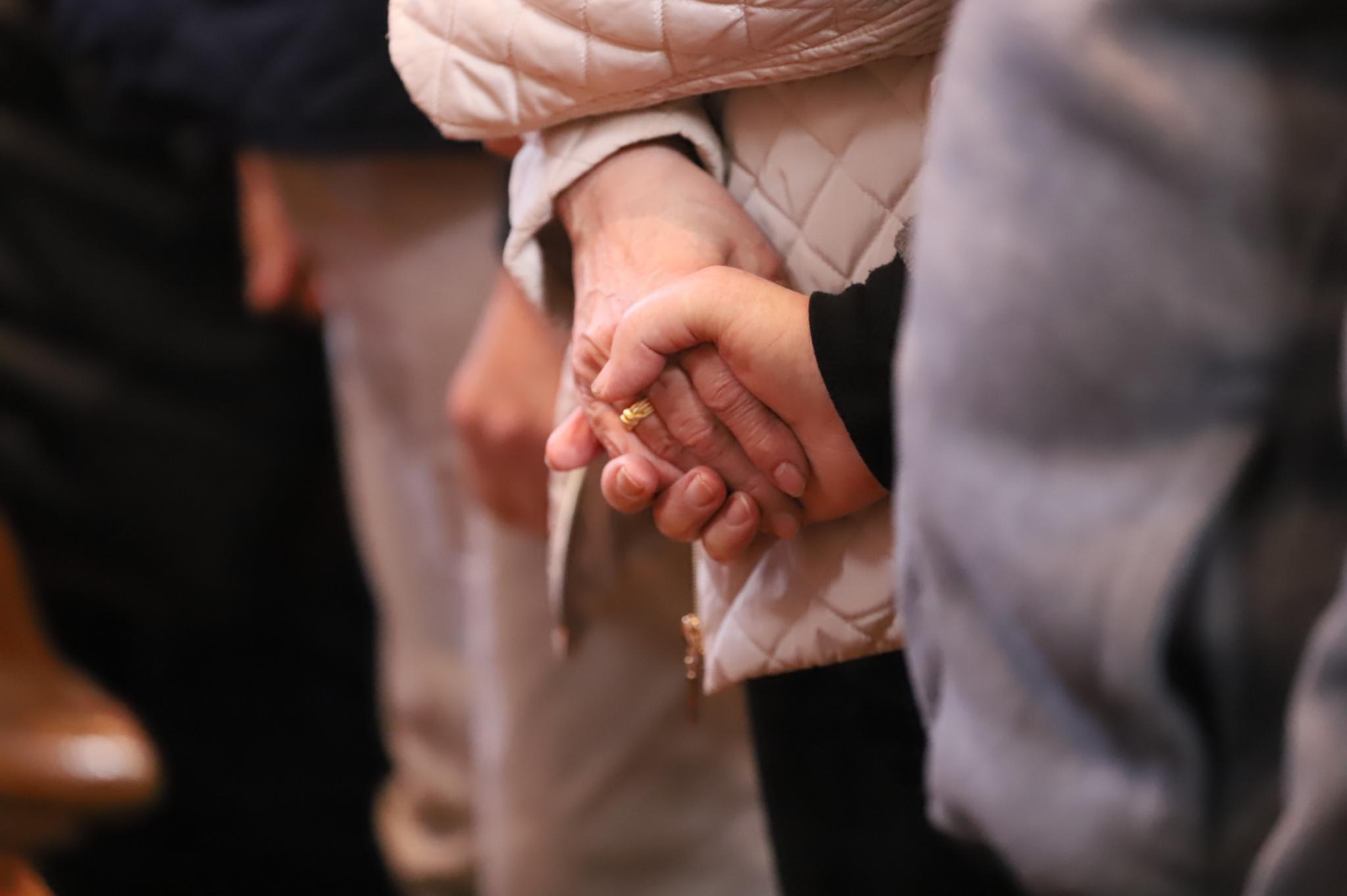 Das Ehepaar reicht sich die Hände im Gottesdienst