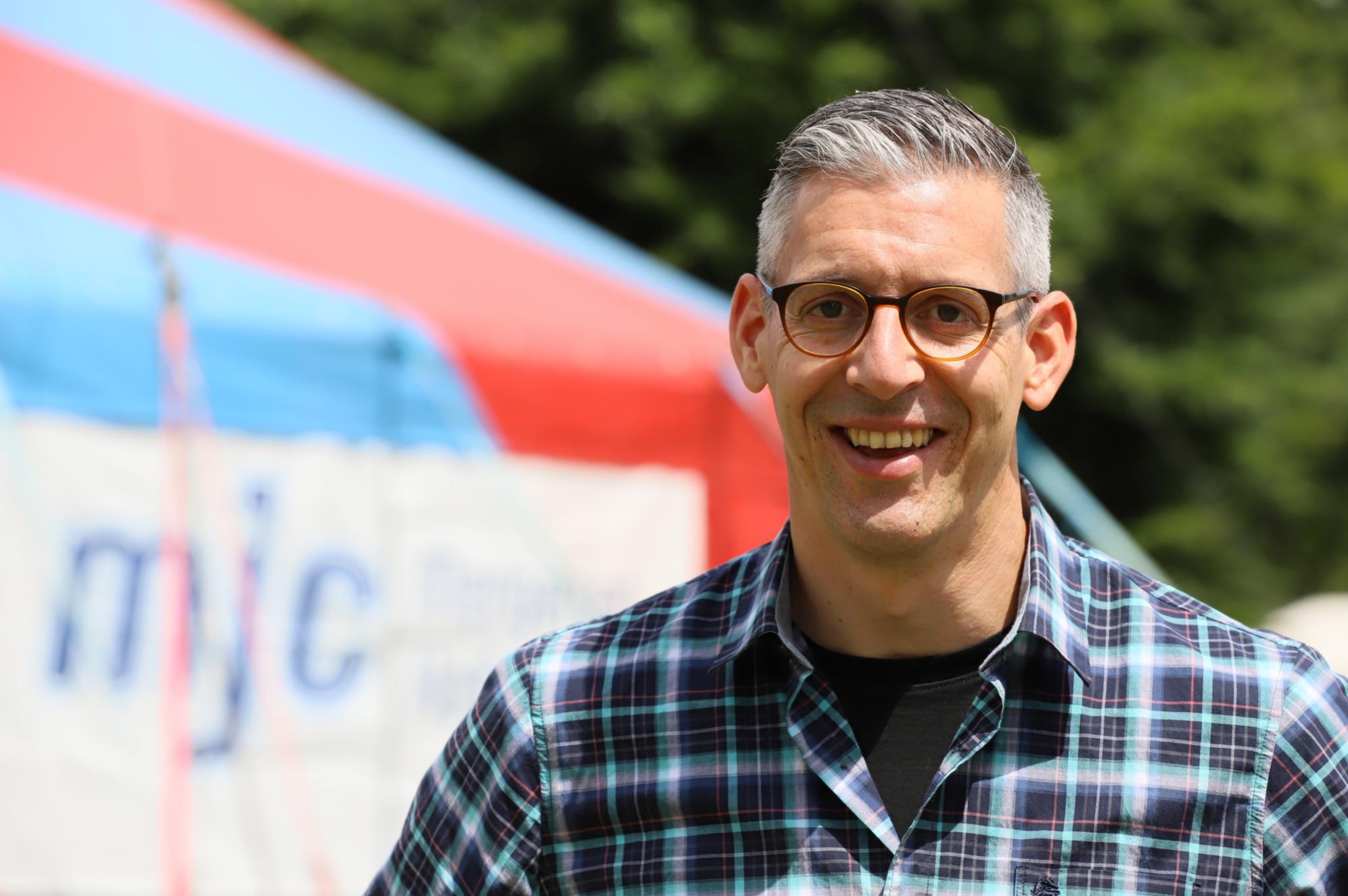 Ein Mann mit Brille lächelt in die Kamera