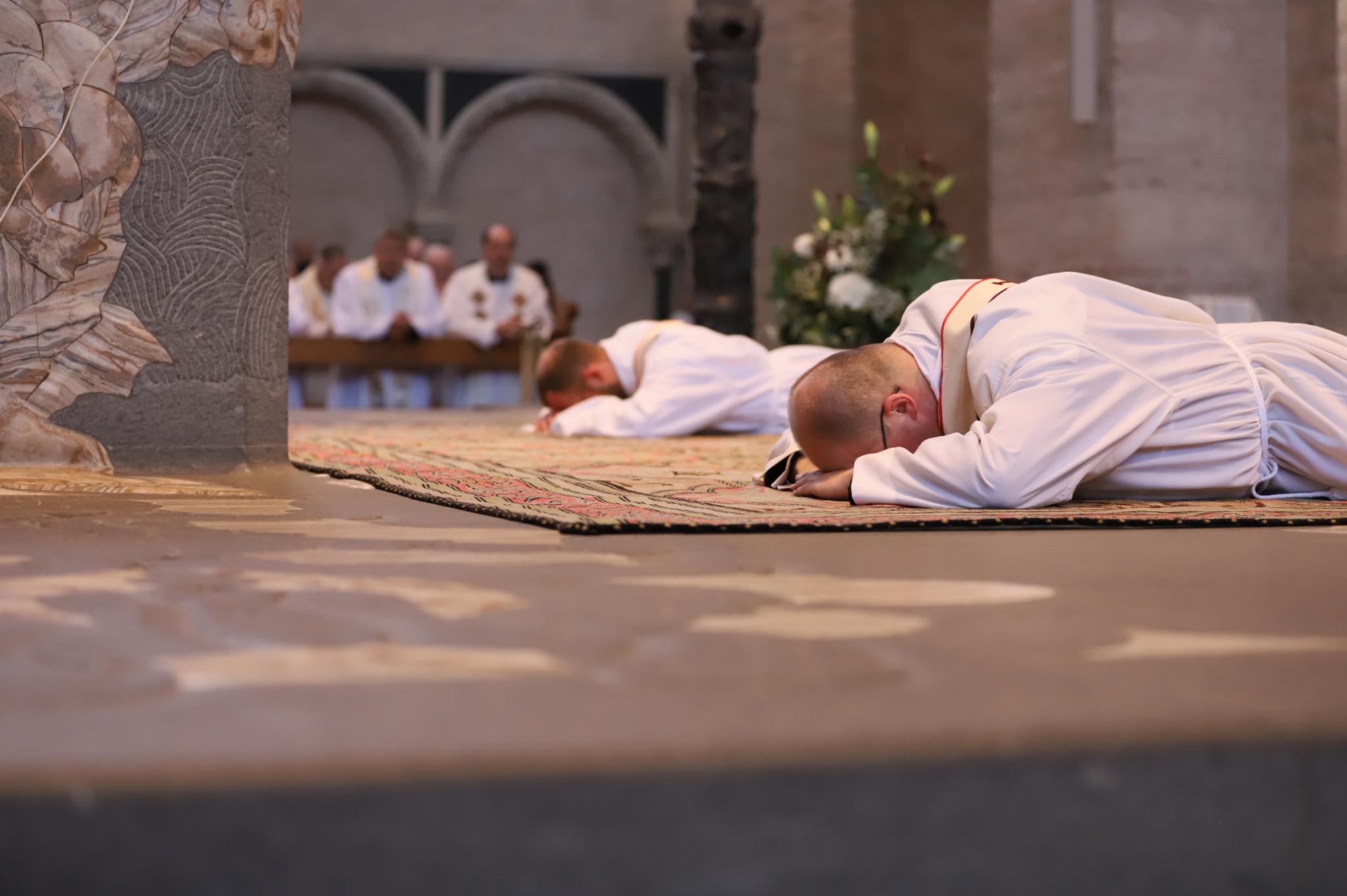 Die beiden Neupriester liegen auf dem Altar