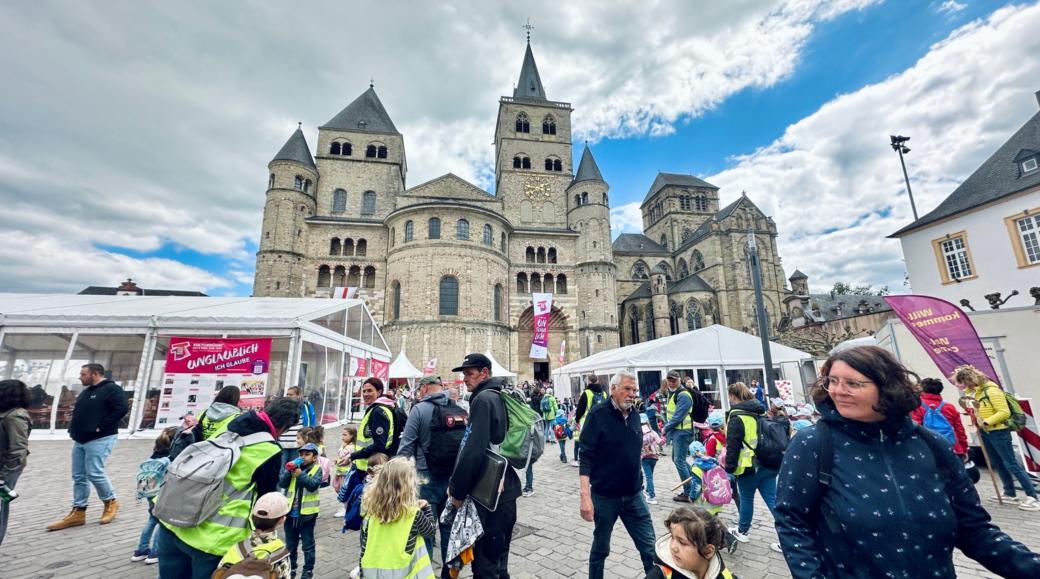 Man sieht den Trierer Dom, Zelte, Pavillions, Fahnen und viele Menschen, die auf dem Domfreihof sind im Rahmen der Heilig-Rock-Tage