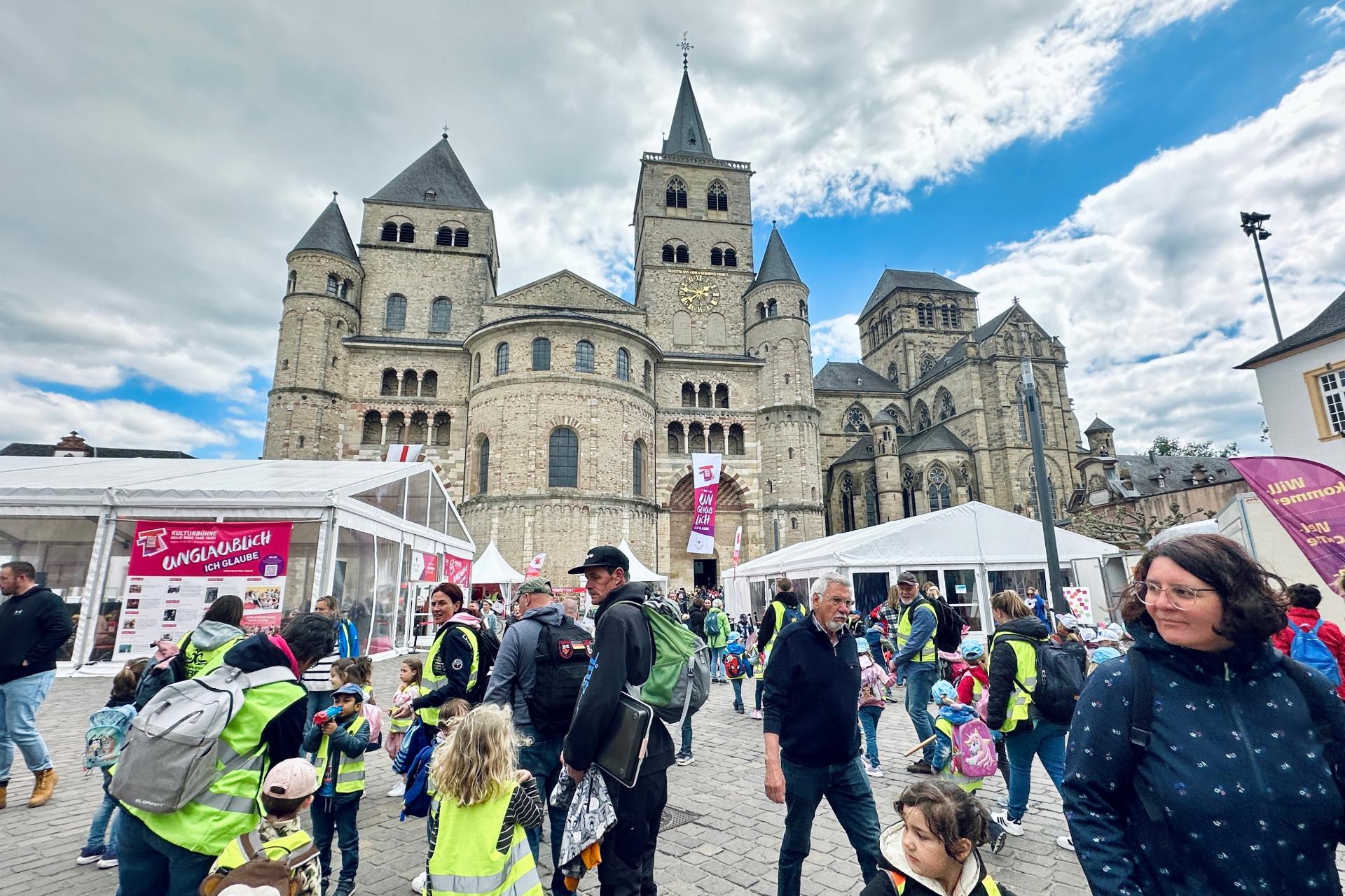 Man sieht den Trierer Dom, Zelte, Pavillions, Fahnen und viele Menschen, die auf dem Domfreihof sind im Rahmen der Heilig-Rock-Tage