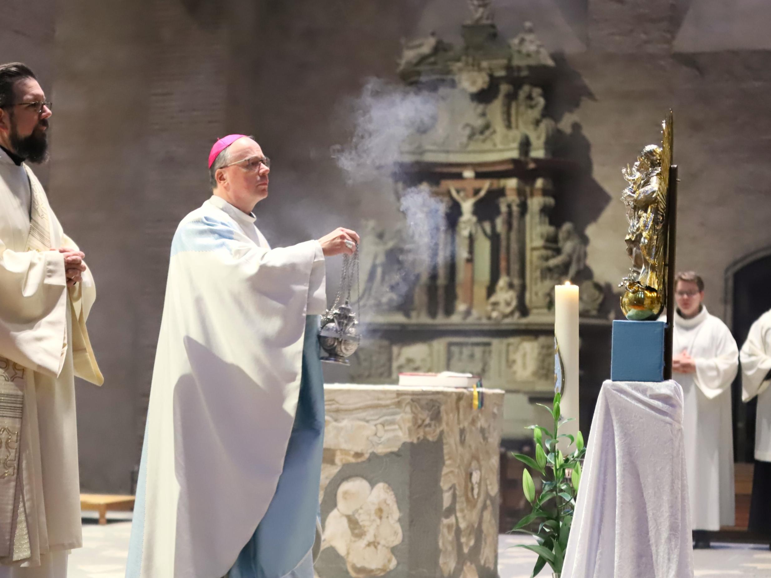 Bischof Ackermann vor der Marienstatue, die am Hochfest Maria Immaculata im Altarraum ihren Platz hat