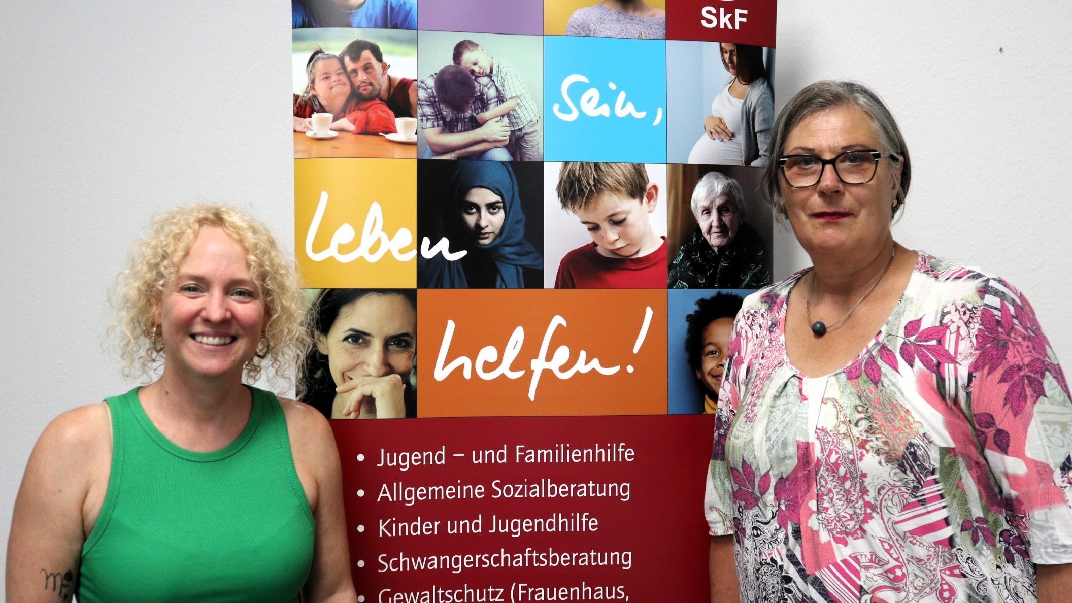 Zwei Frauen stehen vor einem Plakat des SKF Koblenz