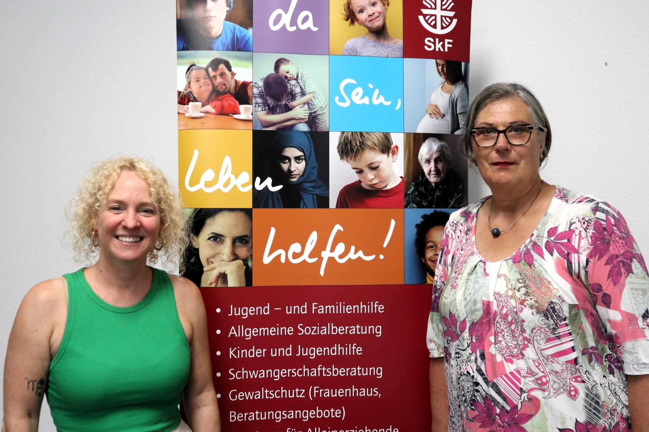 Zwei Frauen stehen vor einem Plakat des SKF Koblenz