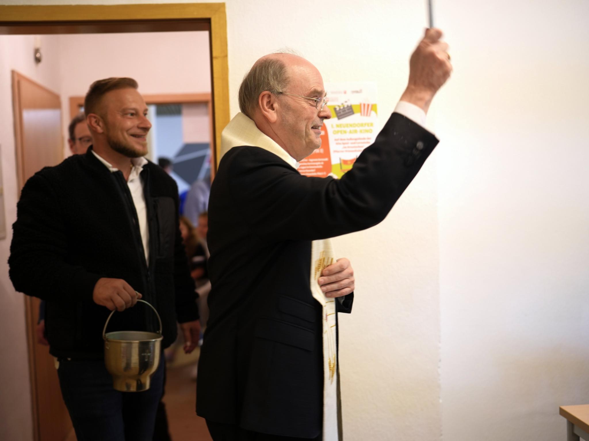 Weihbischof Brahm segnet die Räume.