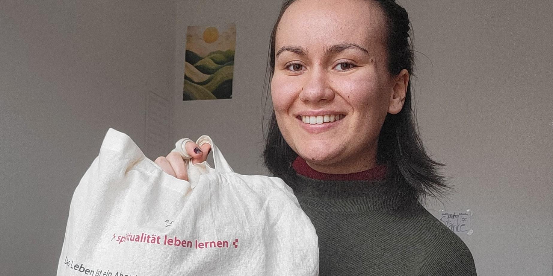 Das Bild zeigt Julia Bodnar mit einem Jute-Beutel in der Hand