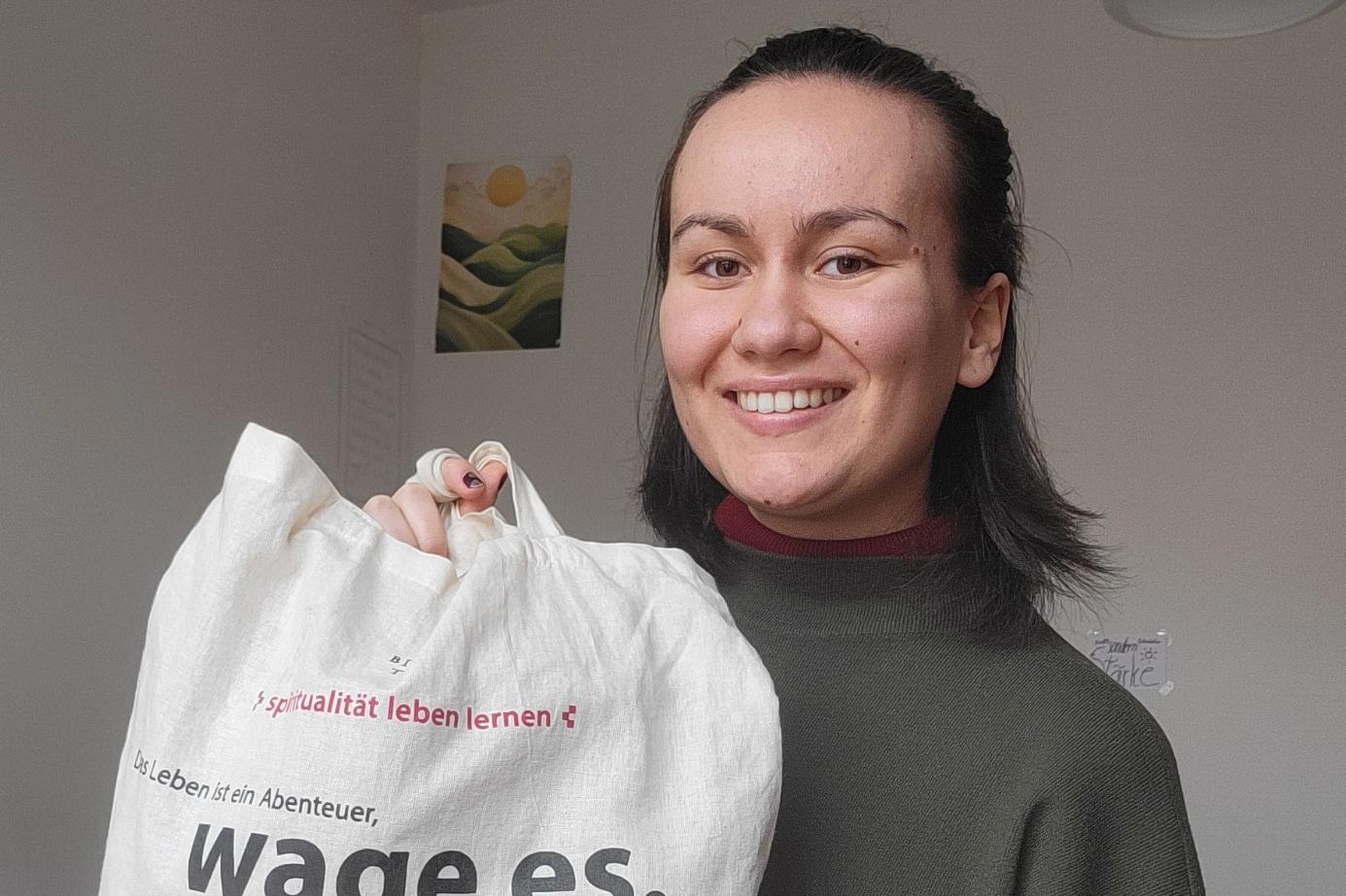 Das Bild zeigt Julia Bodnar mit einem Jute-Beutel in der Hand