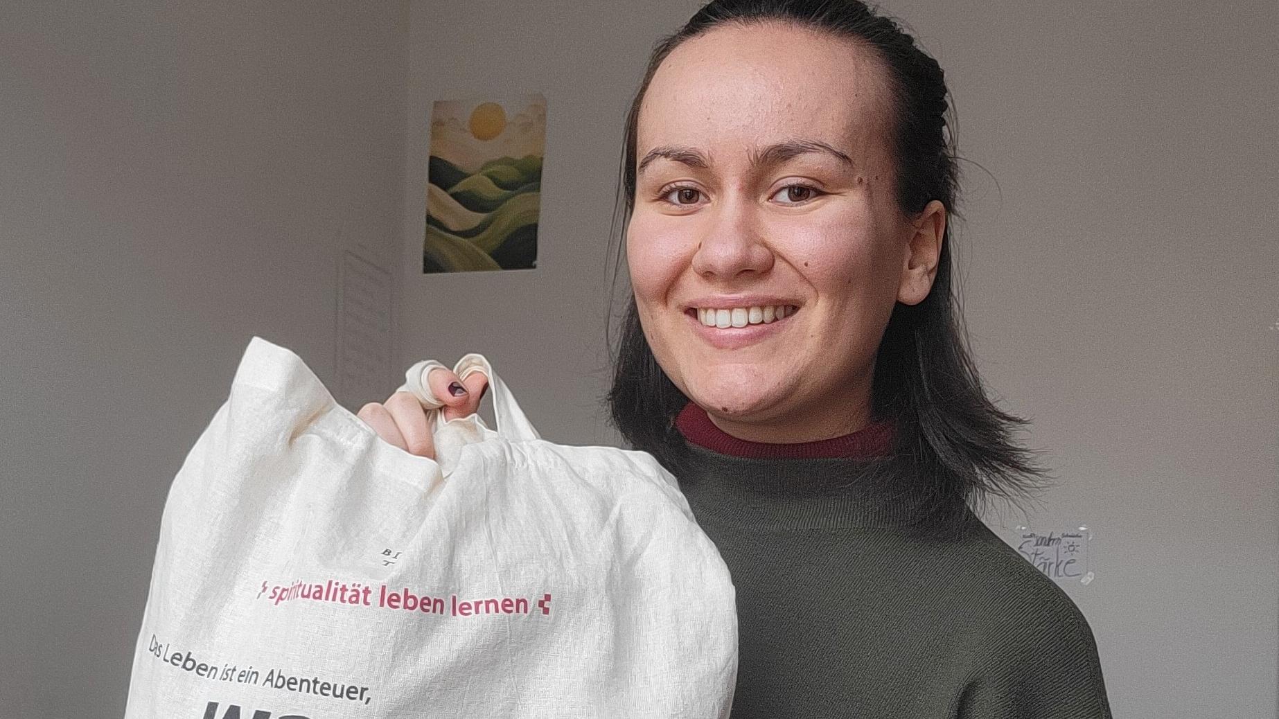 Das Bild zeigt Julia Bodnar mit einem Jute-Beutel in der Hand