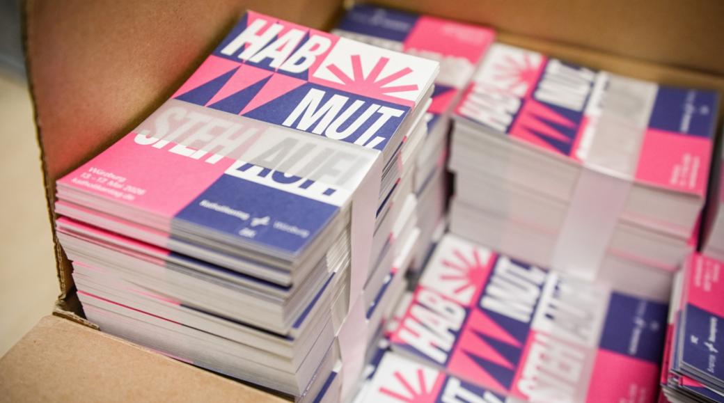 Karten mit dem Katholikentags-Leitspruch „Hab Mut, steh auf!“ in der Geschäftsstelle des Katholikentags in Würzburg.