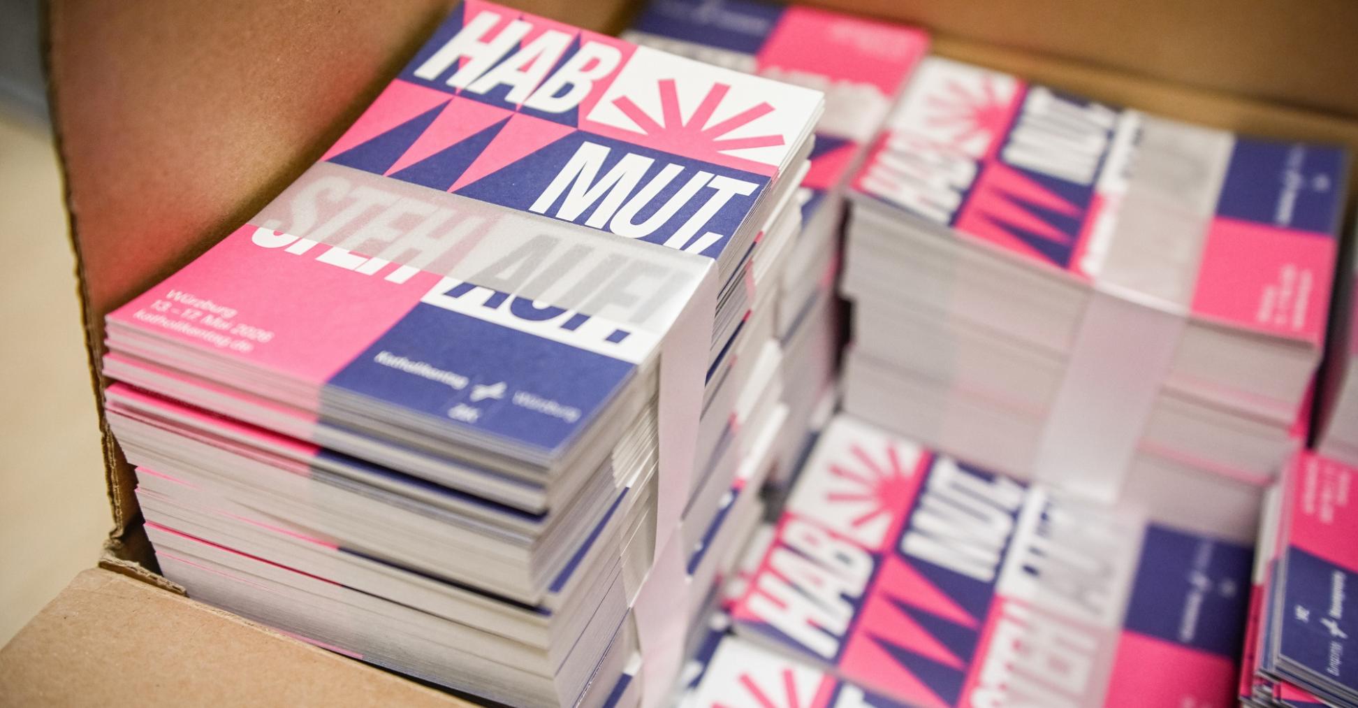 Karten mit dem Katholikentags-Leitspruch „Hab Mut, steh auf!“ in der Geschäftsstelle des Katholikentags in Würzburg.