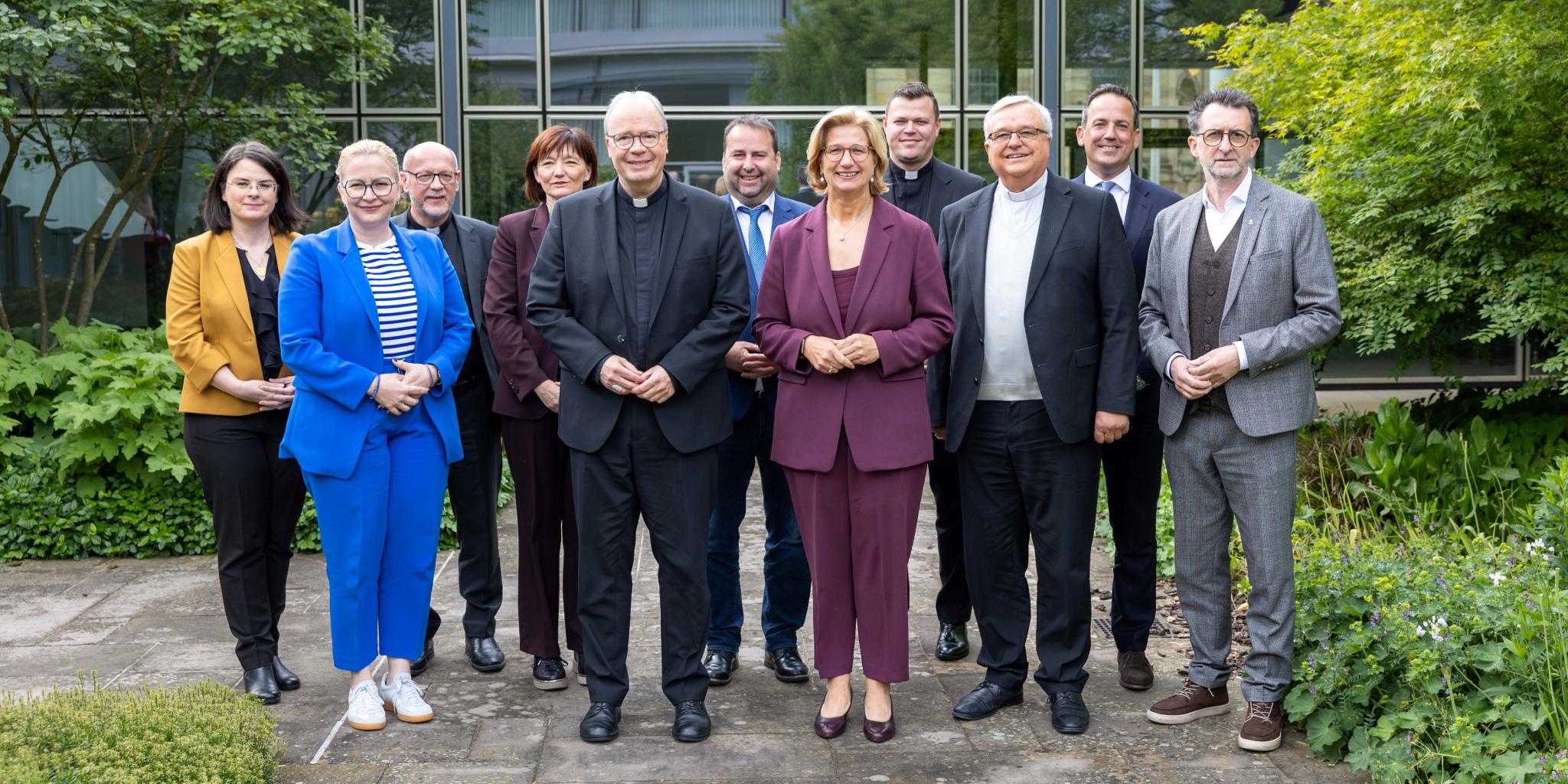 Eine Gruppe aus Frauen und Männern lächelt in die Kamera