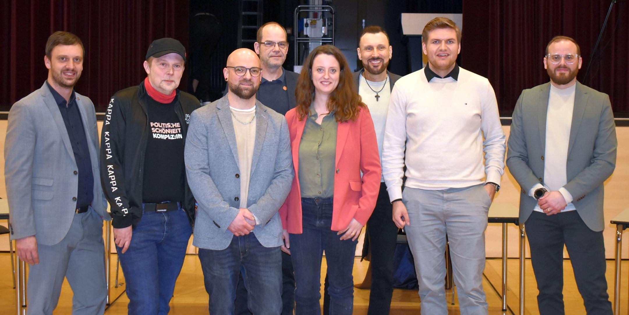 Eine Frau und sieben Männer schauen freundlich in die Kamera.