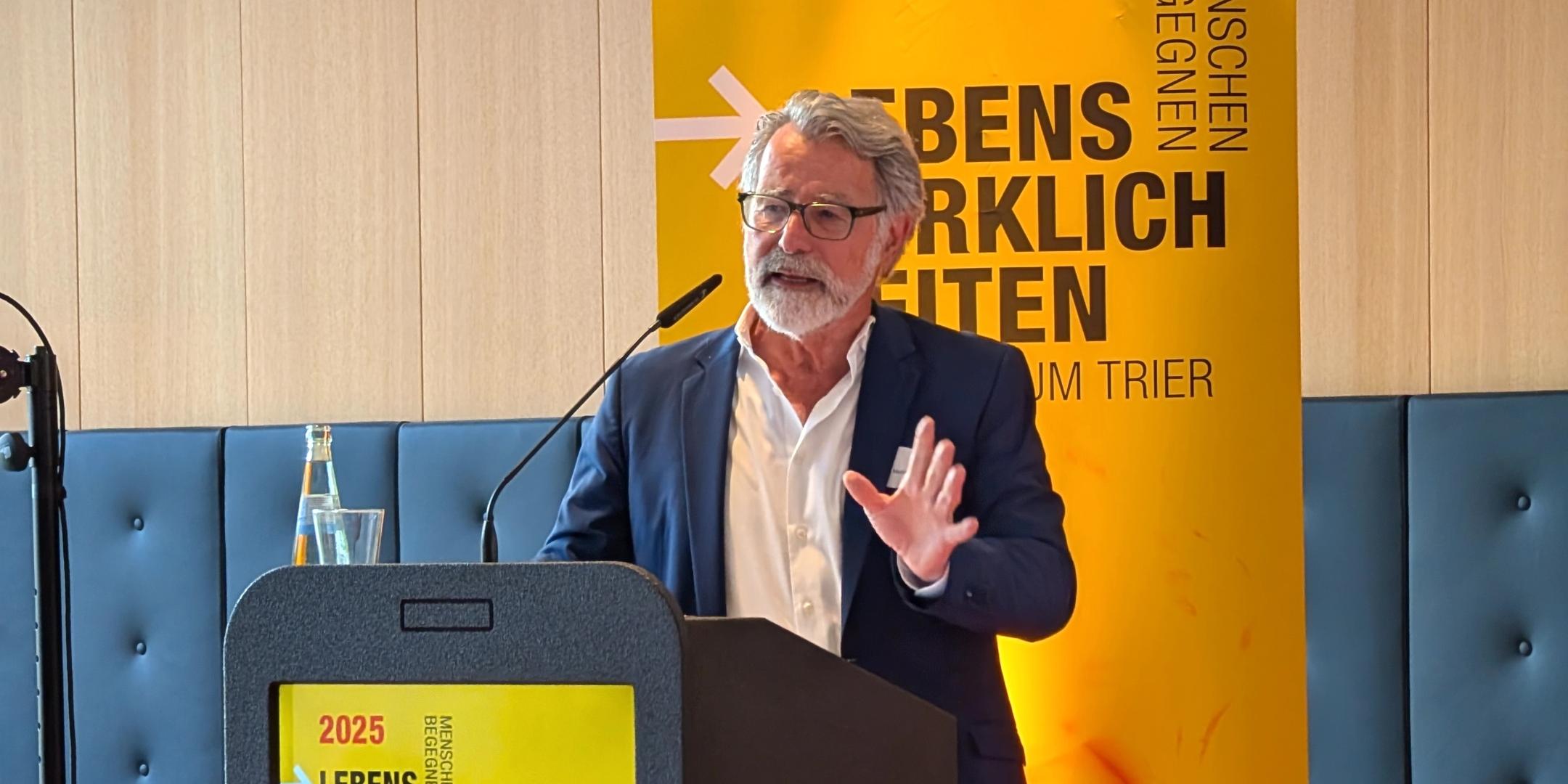 Ein Mann spricht bei einer Konferenzveranstaltung in einem Tagungsraum.