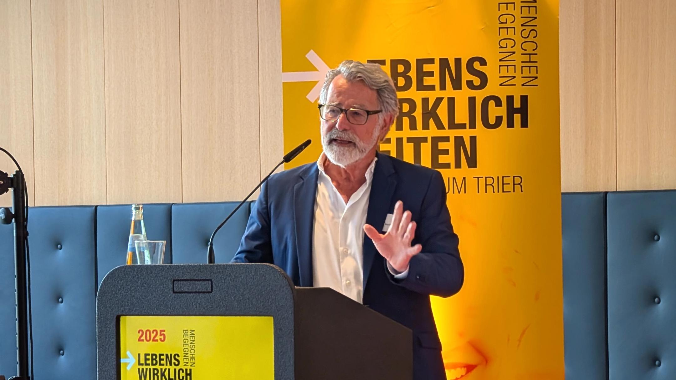 Ein Mann spricht bei einer Konferenzveranstaltung in einem Tagungsraum.