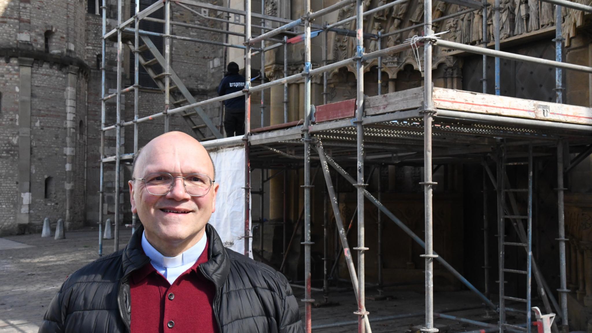 Pfarrer Dr. Markus  Nicolay vor dem restaurierten Westportal der Trierer Liebfrauenbasilika.