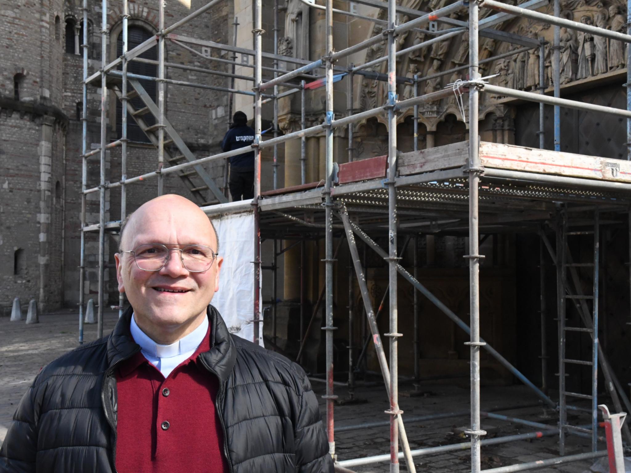 Pfarrer Dr. Markus  Nicolay vor dem restaurierten Westportal der Trierer Liebfrauenbasilika.