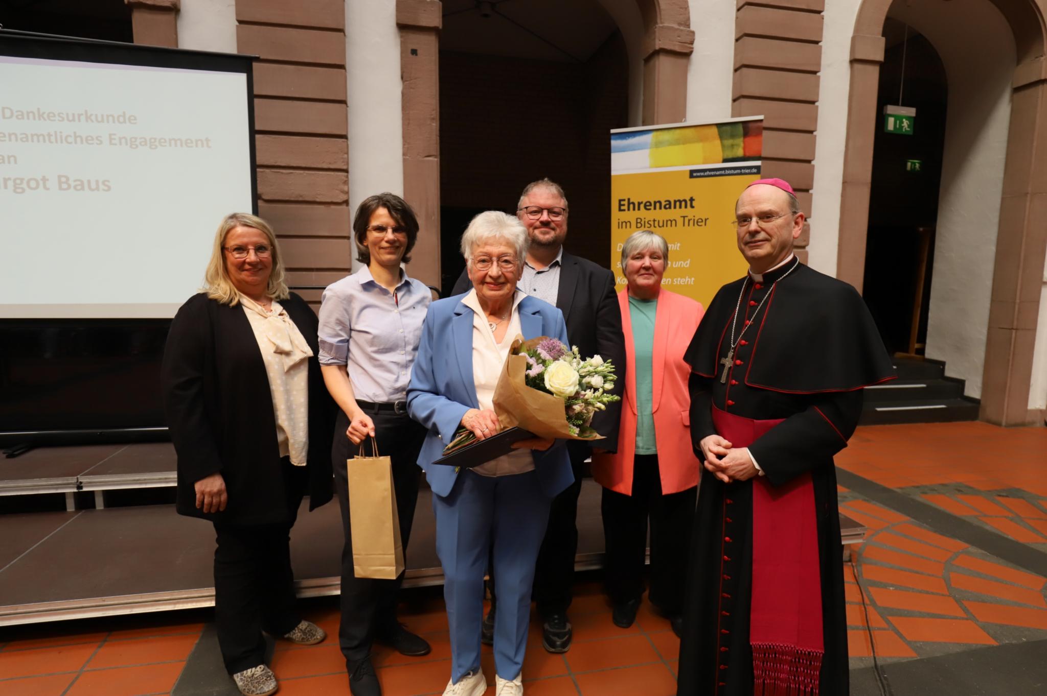 Margot Baus (vorne) erhält die Dankesurkunde des Bistums Trier.
