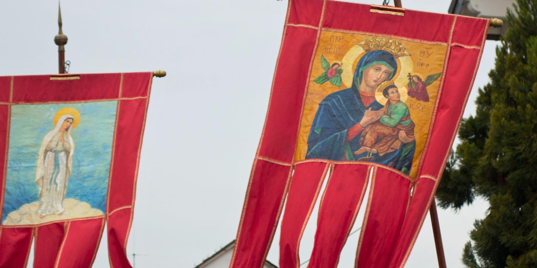Mit unterschiedlichen Fahnen zieht die Pilgergruppe von Hillesheim nach Koblenz