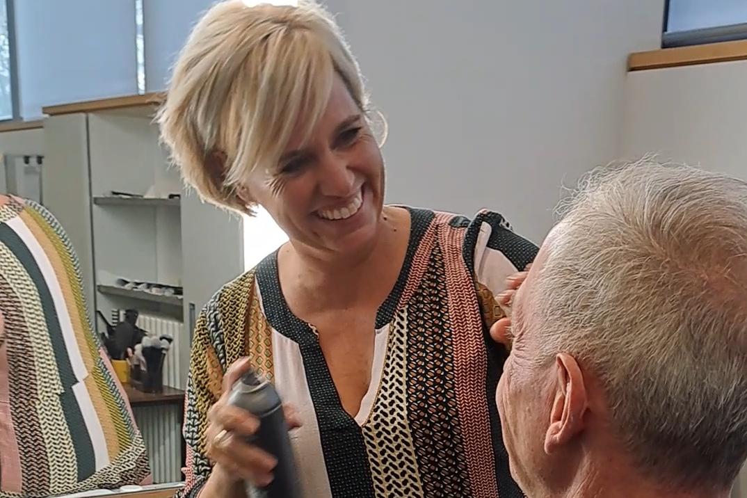 Maskenbildnerin Katja Texter benutzt das Make-up Setting Spray an Pfarrer Benedikt Welter