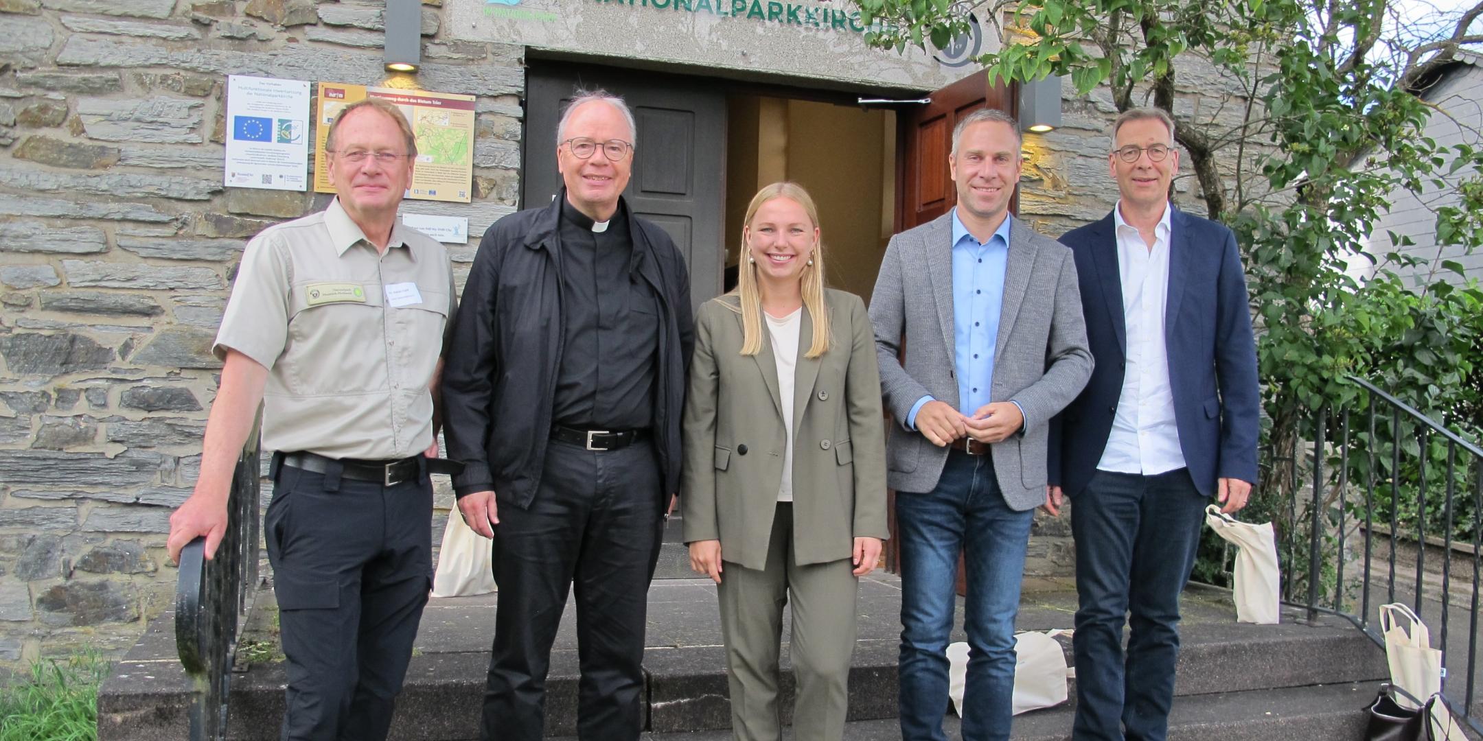 Dr. Harald Egidi, Bischof Dr. Stephan Ackermann, Kira Braun, Nico Steinbach und Superintendent Dr. Jörg Weber stehen vor dem Eingang zur Kirche von Muhl