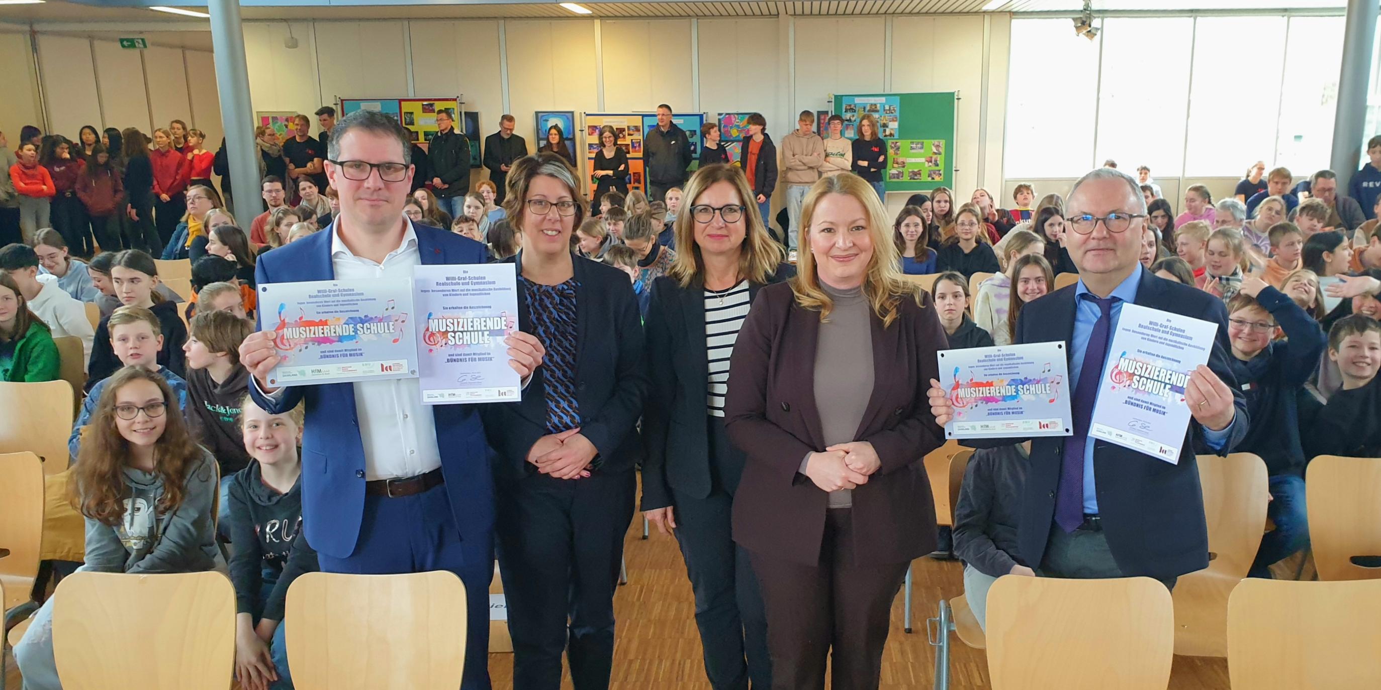 Freuten sich über die Auszeichnung der Willi-Graf-Schulen als 'Musizierende Schulen': Stephan Arnold (Schulleiter Realschule), Kerstin Schmitz (Leiterin des Arbeitsbereich Katholische Schulen im Bischöflichen Generalvikariat), Eva Kieser (Vizepräsidentin des Bundesverbandes für Musikunterricht und Projektleiterin zur Ausbildung der Musikmentoren in der Landesakademie in Ottweiler), Christine Streichert-Clivot (Ministerin für Bildung und Kultur des Saarlandes) und Stefan Kilz (Leiter des Gymnasiums)